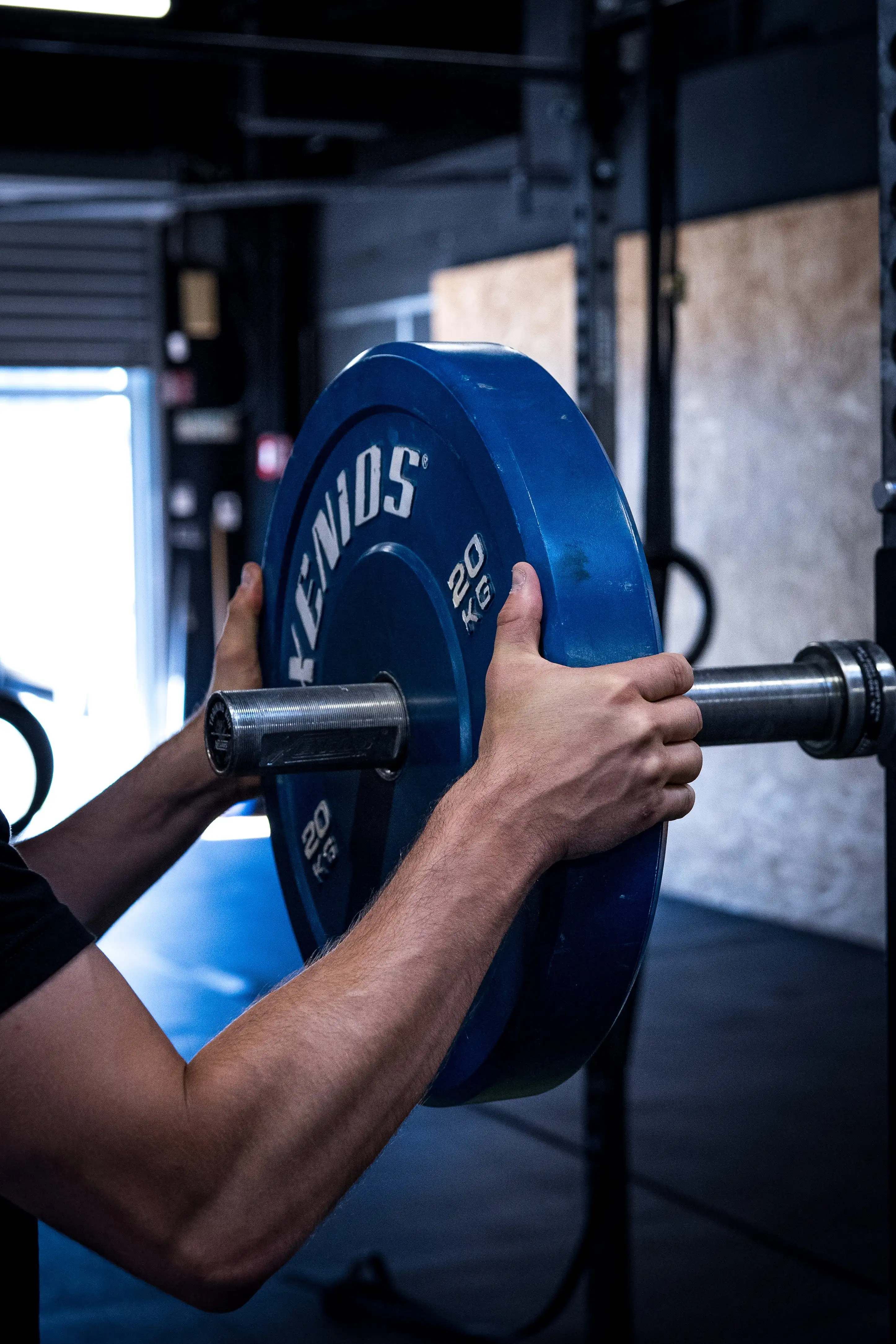 sportif qui charge sa barre d'haltérophilie